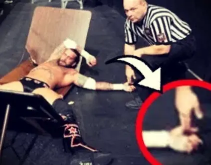 WWE referee checking on a wrestling with a hand squeeze